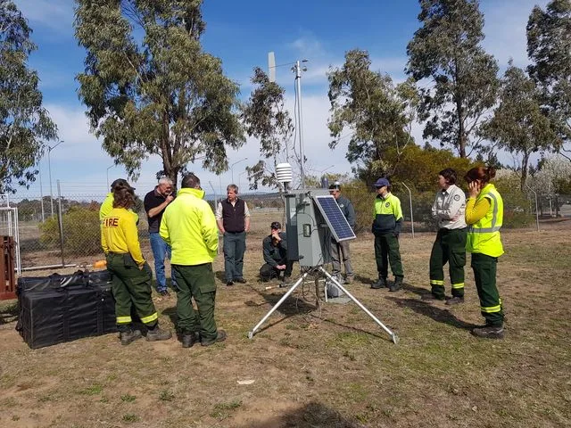 Fire crews gathered around a portable automatic weather station